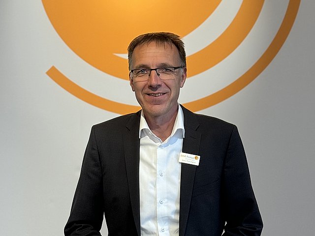Marc Pohlmann vor dem BKK Logo