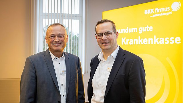 Zwei Männer in Geschädtskleidung schauen lächelnd in die Kamera