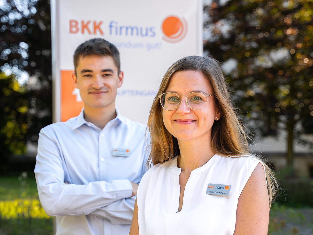 Zwei Mitarbeitende vor dem Gebäude der BKK firmus