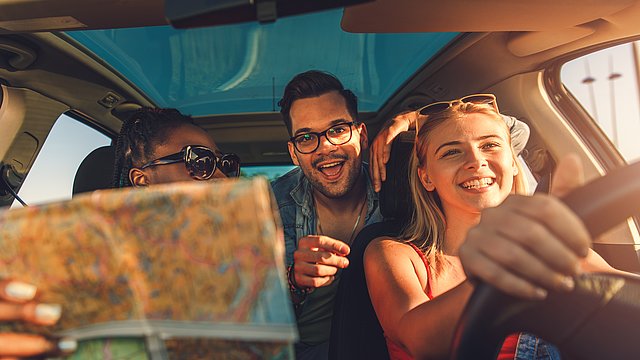Lachende Personengruppe im Auto