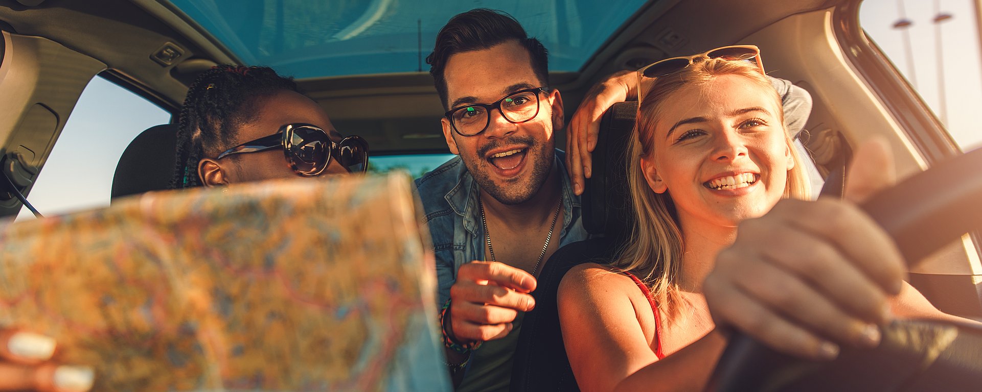 Lachende Personengruppe im Auto