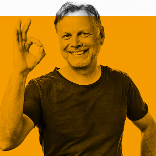 Lächelnder Mann im T-Shirt, der eine OK-Handgeste auf orange-weißem Hintergrund macht.