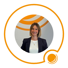 Lächelnde Frau mit glattem, blondem Haar in einem Blazer, innerhalb einer orangefarbenen Kreisgrafik auf weißem Hintergrund.
