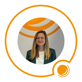 Frau mit glattem blondem Haar und Brille, lächelnd, vor einem orange-weißen Kreismuster.